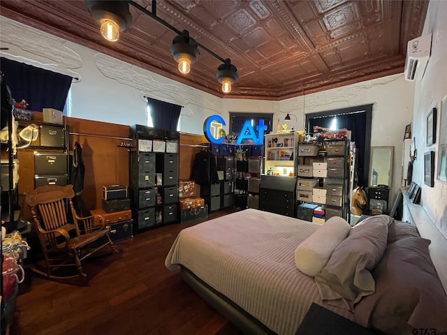 bedroom with a wall mounted air conditioner and hardwood / wood-style flooring