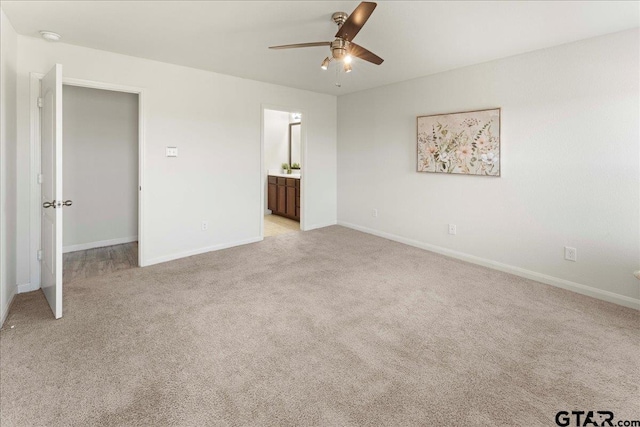 unfurnished bedroom with ensuite bath, light colored carpet, and ceiling fan