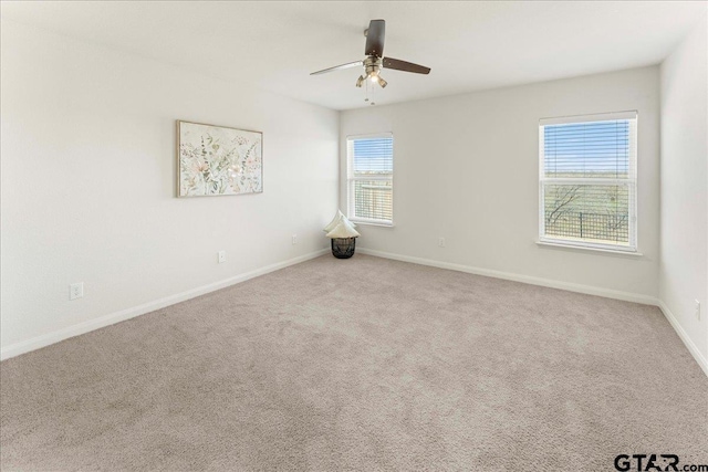 carpeted spare room featuring ceiling fan