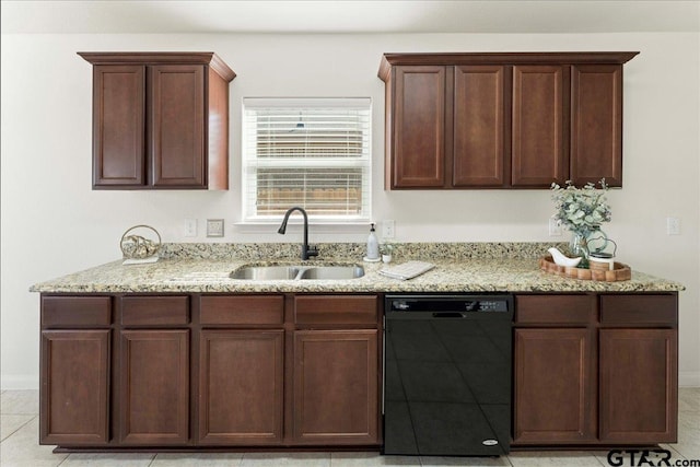 kitchen with light stone counters, black dishwasher, and sink