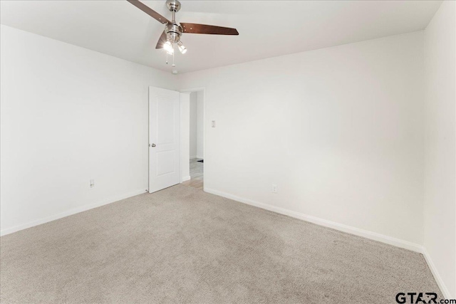 unfurnished room with light colored carpet and ceiling fan