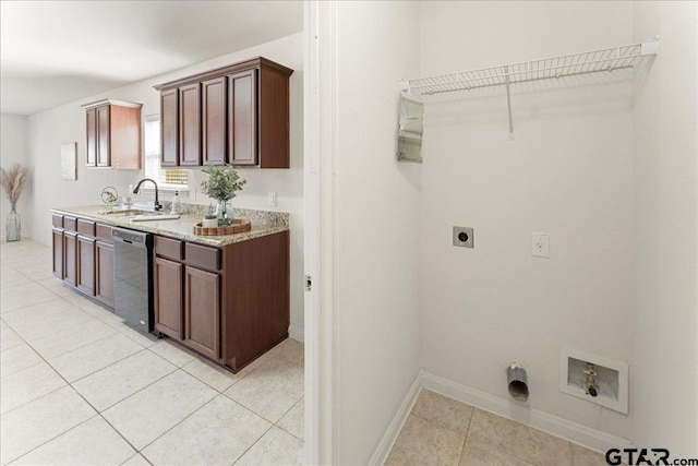 laundry area with electric dryer hookup, sink, and light tile patterned floors