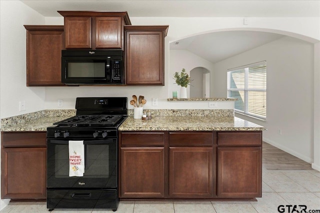 kitchen featuring light stone countertops, vaulted ceiling, black appliances, and kitchen peninsula