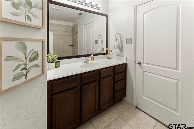 bathroom with vanity, tile patterned floors, and a tile shower