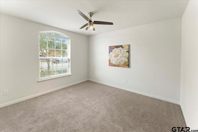 carpeted spare room featuring ceiling fan