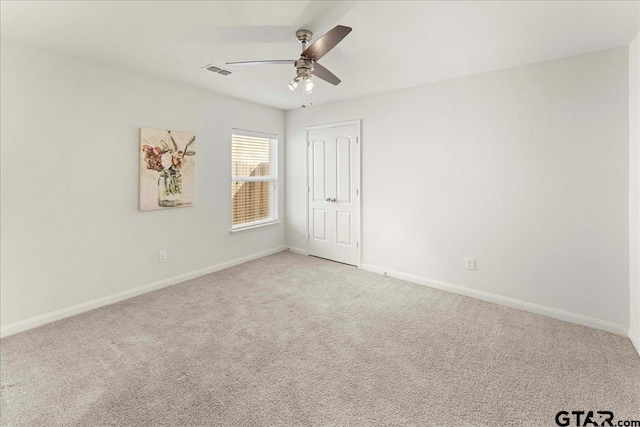 unfurnished room featuring ceiling fan and carpet