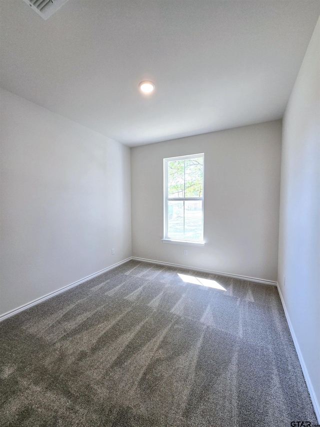 unfurnished room featuring carpet and baseboards