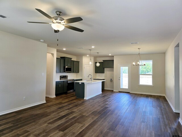 kitchen featuring stainless steel appliances, a sink, dark wood-type flooring, baseboards, and ceiling fan
