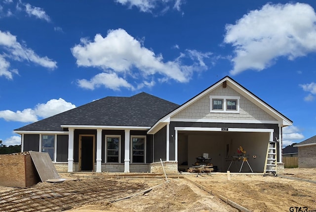 view of front of home with stone siding, a shingled roof, and a sunroom