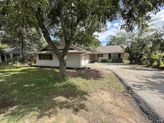 ranch-style house with a garage and a front yard