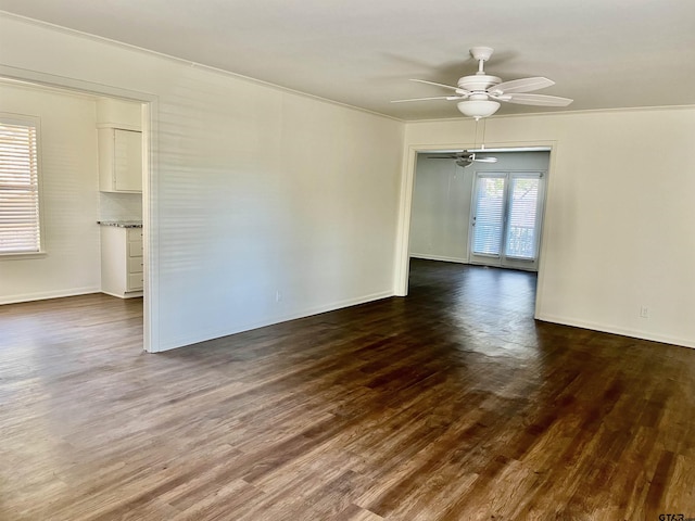 unfurnished room with ceiling fan, a wealth of natural light, and dark hardwood / wood-style floors