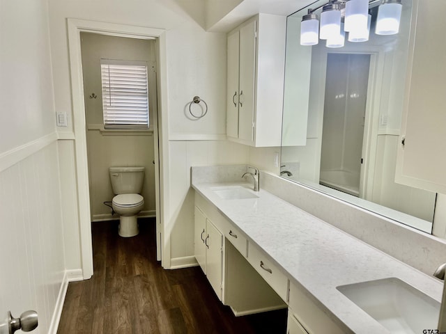 bathroom featuring wood-type flooring, toilet, and vanity