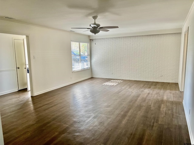 spare room with brick wall, dark hardwood / wood-style flooring, and ornamental molding