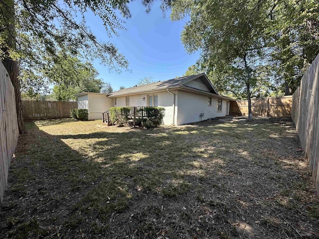 view of home's exterior with a wooden deck and a yard