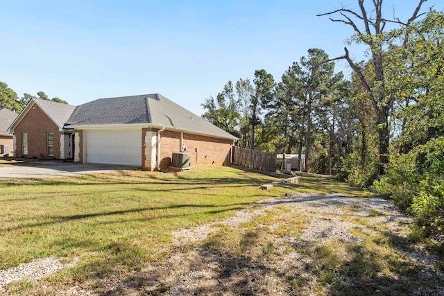 view of property exterior featuring central AC unit, a garage, and a yard