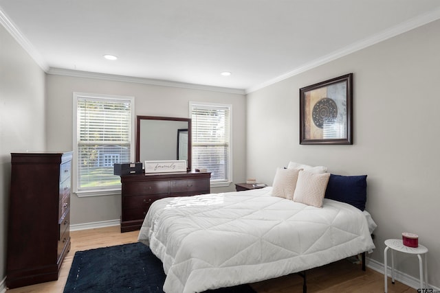 bedroom with ornamental molding, light wood-type flooring, and multiple windows