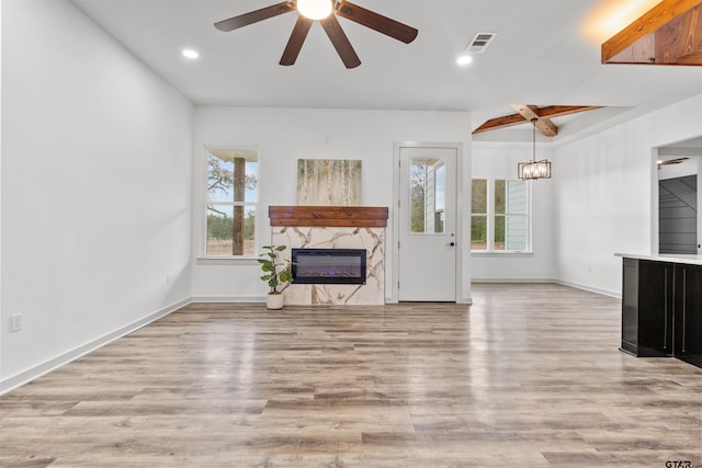 unfurnished living room featuring ceiling fan, light wood-type flooring, and a premium fireplace