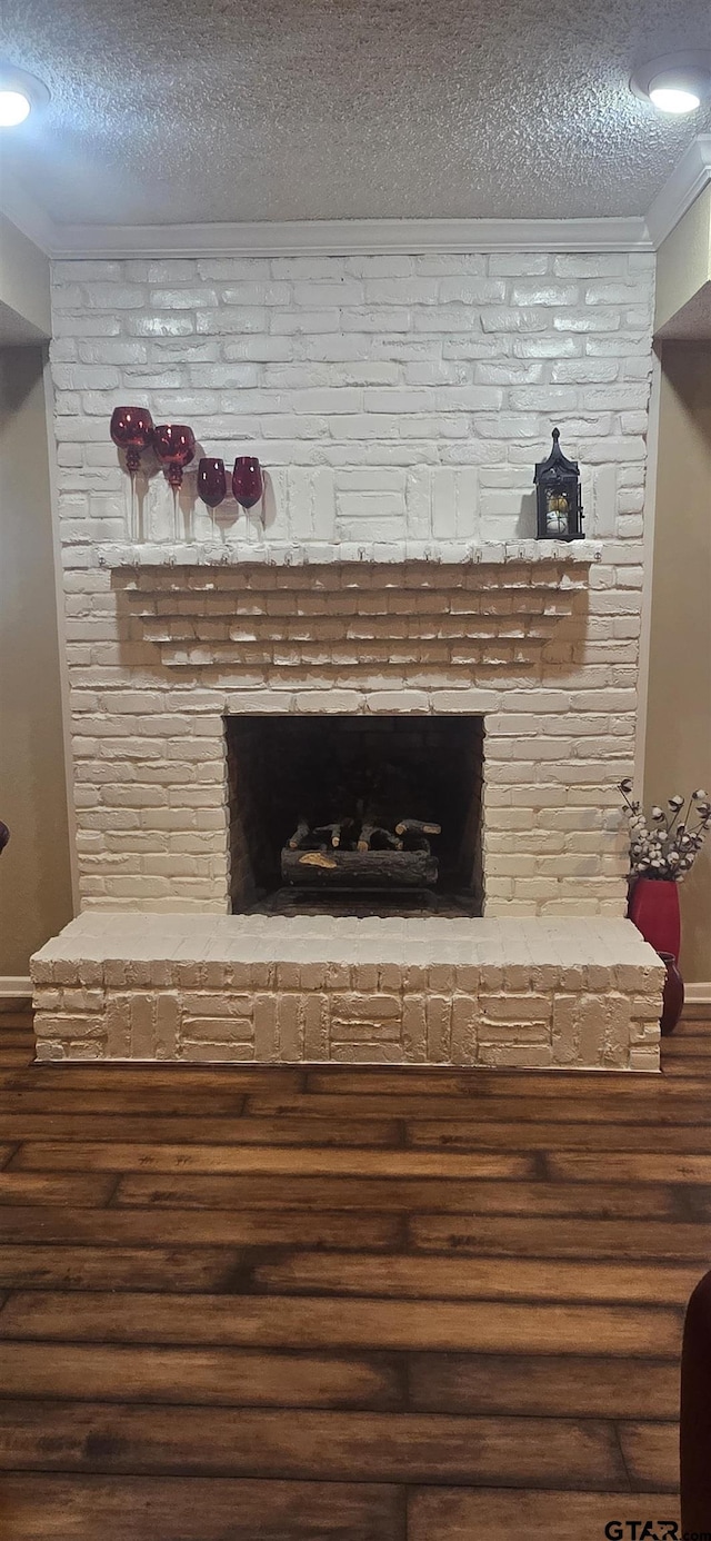 406 Brookwood Dr, Mount Pleasant, TX 75455 - detailed view of a textured ceiling, wood finished floors, a brick fireplace, and crown molding