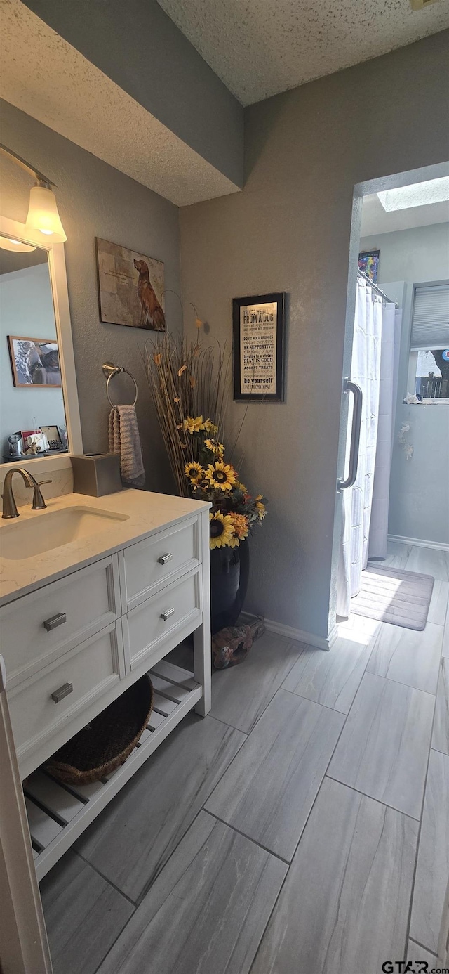 406 Brookwood Dr, Mount Pleasant, TX 75455 - bathroom with vanity, a textured ceiling, wood tiled floors, and curtained shower