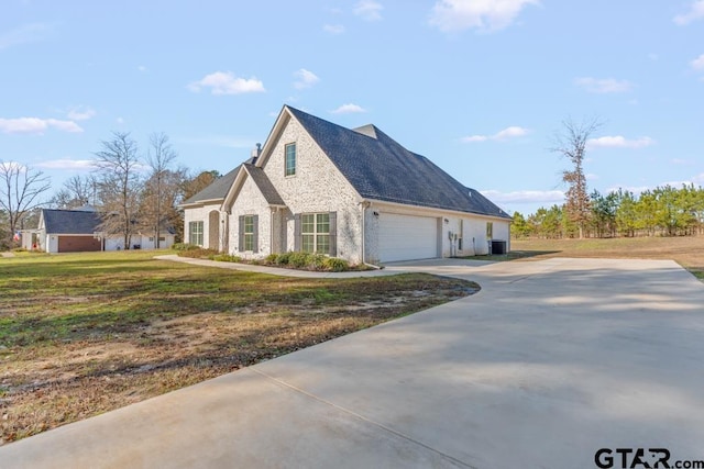 view of side of home featuring a yard and a garage