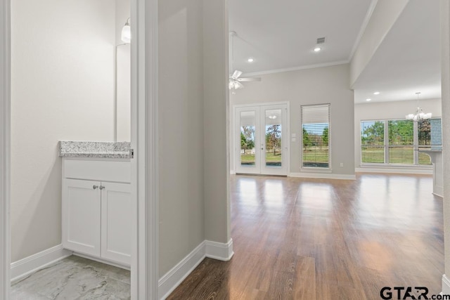 hall with an inviting chandelier and crown molding