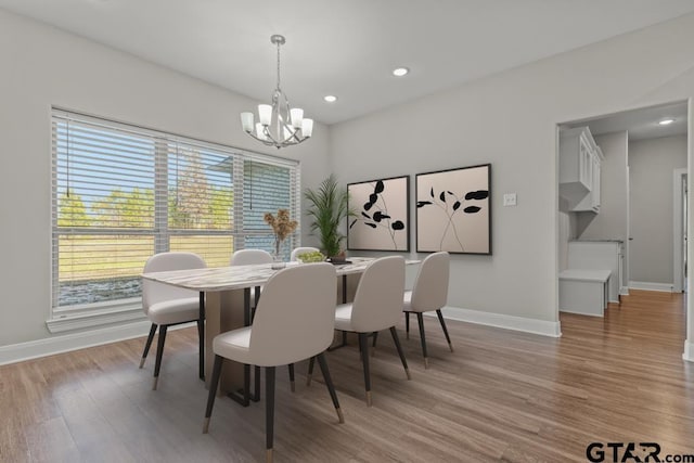 dining room featuring light wood-type flooring and an inviting chandelier