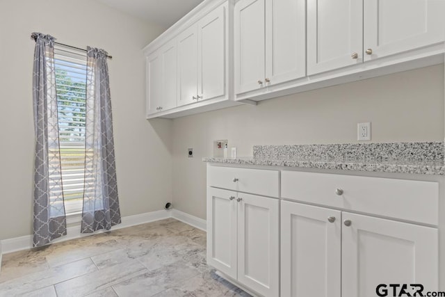 clothes washing area with electric dryer hookup, hookup for a washing machine, and cabinets