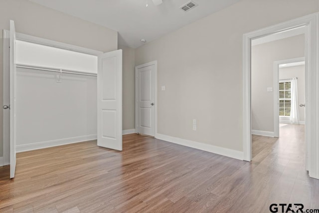 unfurnished bedroom featuring light hardwood / wood-style flooring, a closet, and ceiling fan