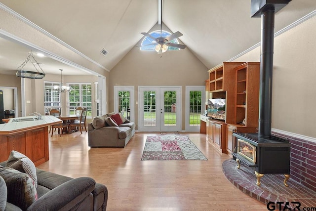 1210 Fm 2137 N, Bullard, TX 75757 - living room with a wood stove, high vaulted ceiling, light wood-style floors, ceiling fan, and a chandelier