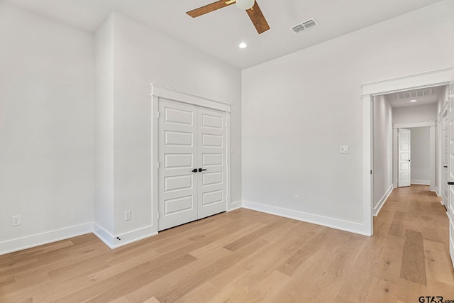 unfurnished bedroom with ceiling fan, a closet, and light wood-type flooring