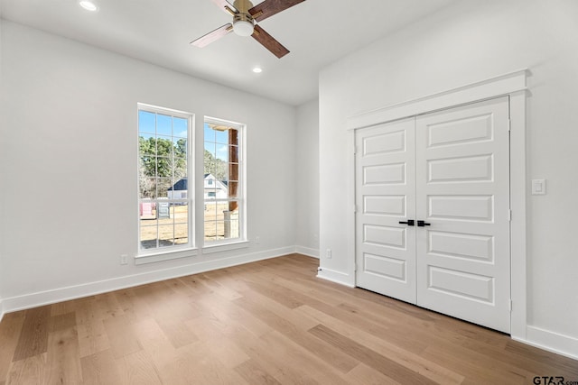 unfurnished bedroom featuring light hardwood / wood-style floors, ceiling fan, and a closet