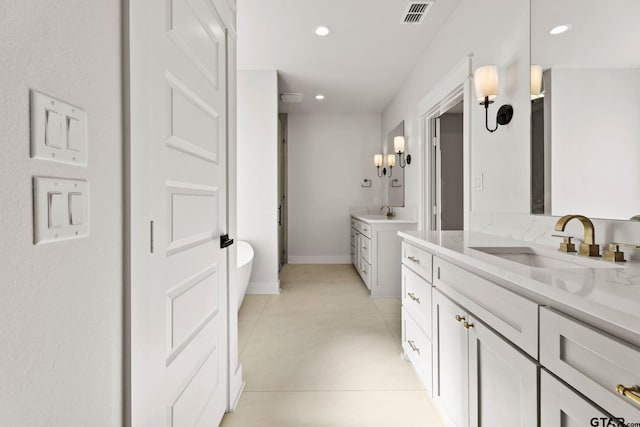 bathroom featuring a tub to relax in, vanity, and tile patterned floors