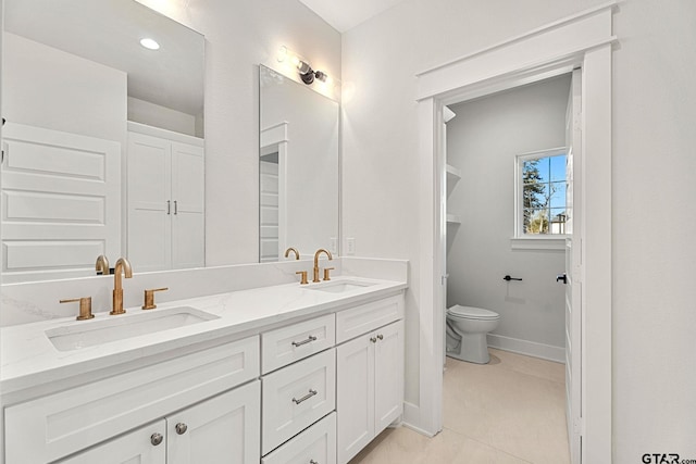 bathroom with tile patterned flooring, vanity, and toilet