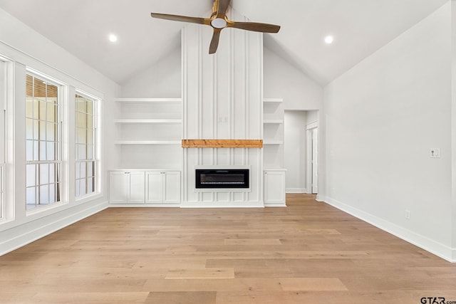 unfurnished living room featuring built in shelves, a fireplace, light hardwood / wood-style floors, and vaulted ceiling