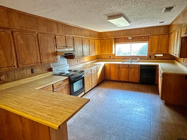 kitchen with a textured ceiling, sink, black appliances, and kitchen peninsula