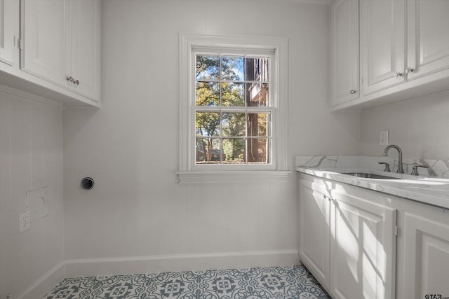 washroom featuring cabinet space, baseboards, and light tile patterned floors