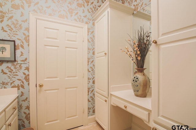 bathroom with wallpapered walls and vanity