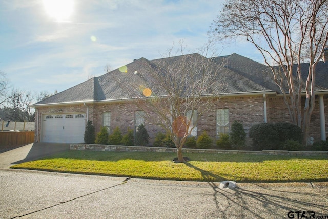 ranch-style home with a front lawn and a garage