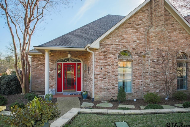 view of front of property with brick siding and roof with shingles