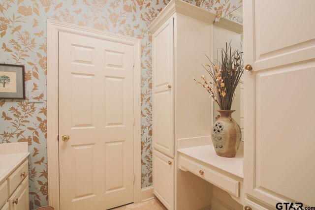 bathroom with vanity and wallpapered walls