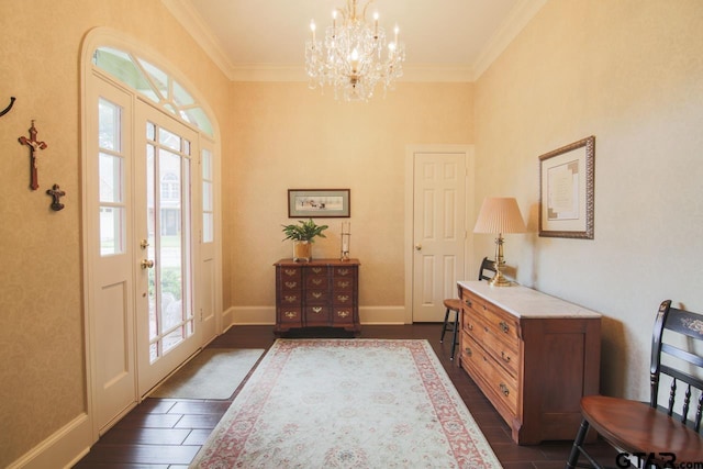 foyer entrance featuring ornamental molding, a chandelier, dark wood-type flooring, and baseboards