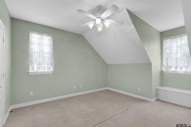 bonus room featuring a wealth of natural light, lofted ceiling, ceiling fan, and light colored carpet