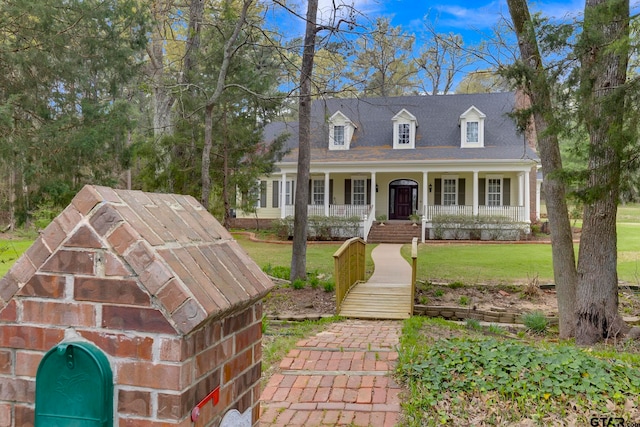 cape cod-style house featuring a front yard and a porch