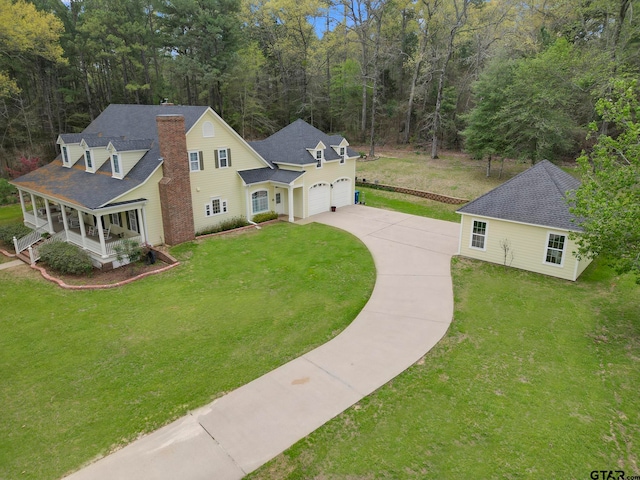 view of front of property featuring a garage, a front lawn, and a porch