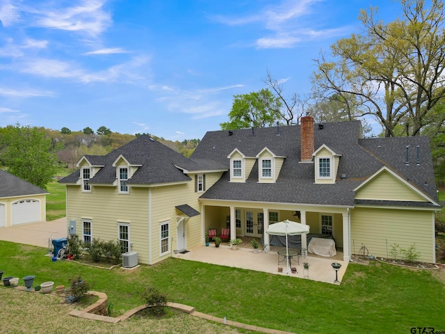 back of property featuring a patio, a garage, central AC, and a yard