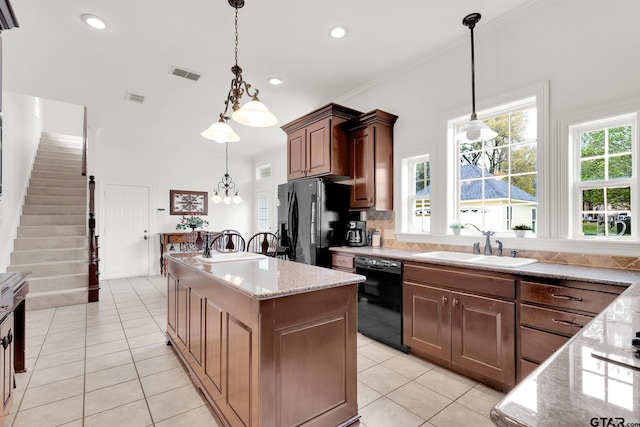 kitchen featuring black appliances, sink, an island with sink, and light tile patterned floors