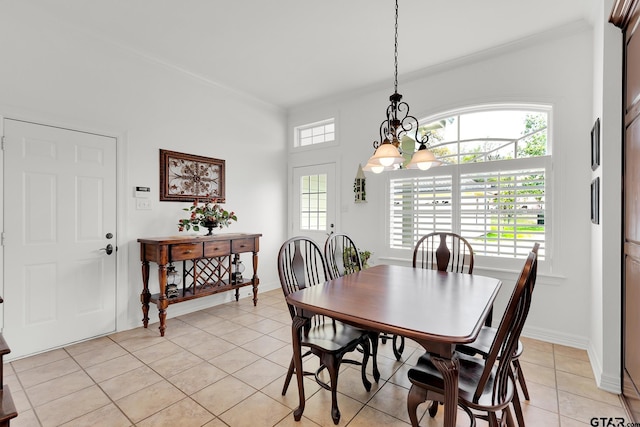 tiled dining area with ornamental molding and an inviting chandelier