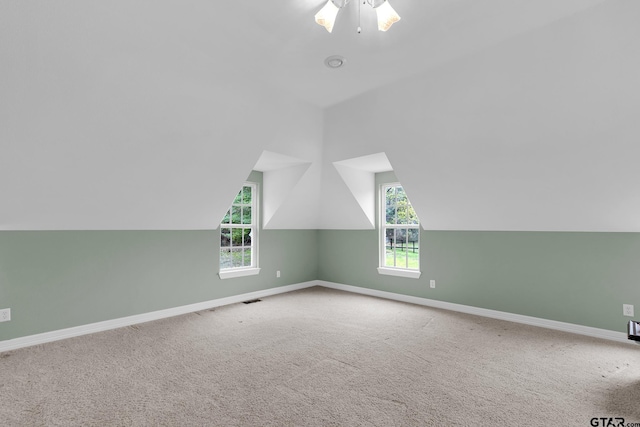 bonus room with ceiling fan, a wealth of natural light, lofted ceiling, and carpet flooring