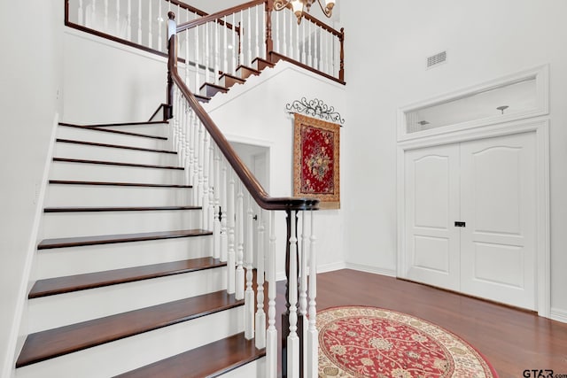 foyer entrance featuring a towering ceiling and wood-type flooring