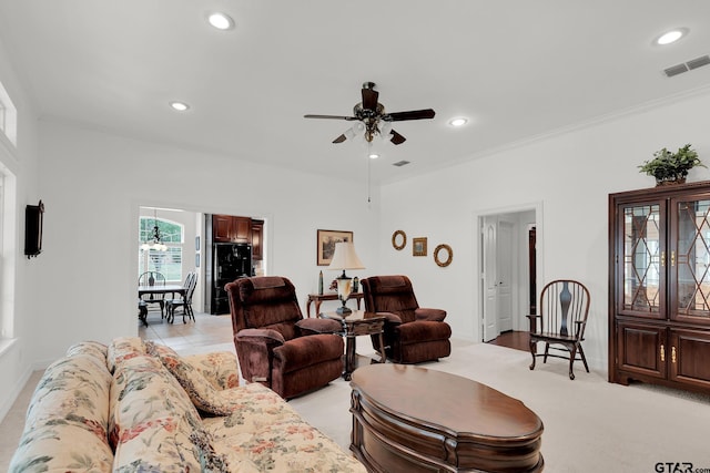 carpeted living room featuring ceiling fan and crown molding